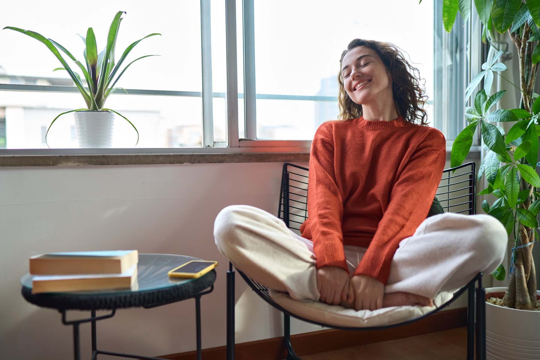 A woman relaxing in a sunny chair at home